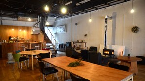 Un restaurante acogedor con mesas y sillas de madera, una zona de bar y una chimenea.