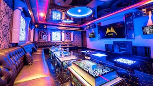 Un elegante bar con sofá de cuero, barra y iluminación decorativa.