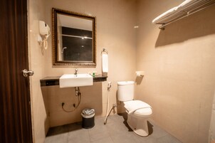 Un baño con lavabo, inodoro y espejo.