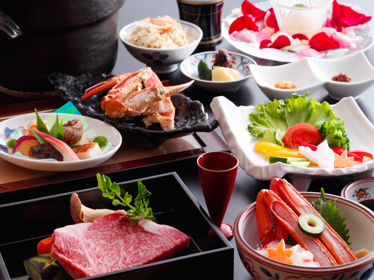 Diversos pratos, incluindo frutos do mar, vegetais e carne, dispostos sobre uma mesa com estética tradicional japonesa.