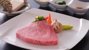 Une assiette contenant une tranche de viande rose, des légumes et une petite portion de sauce.
