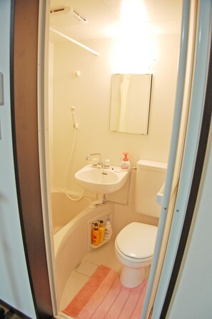 A small bathroom with a sink, toilet, and shower. - Guest House MAKOTOGE - Hostel (Aso)