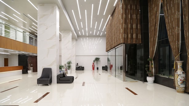 A spacious lobby with a high ceiling, modern lighting, and a reception desk. - Pacific Hotel (Yangon)
