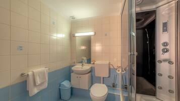 Une salle de bain avec des toilettes, un lavabo et une douche.