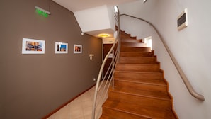 Una escalera de madera con barandilla curva que conduce a una plataforma.