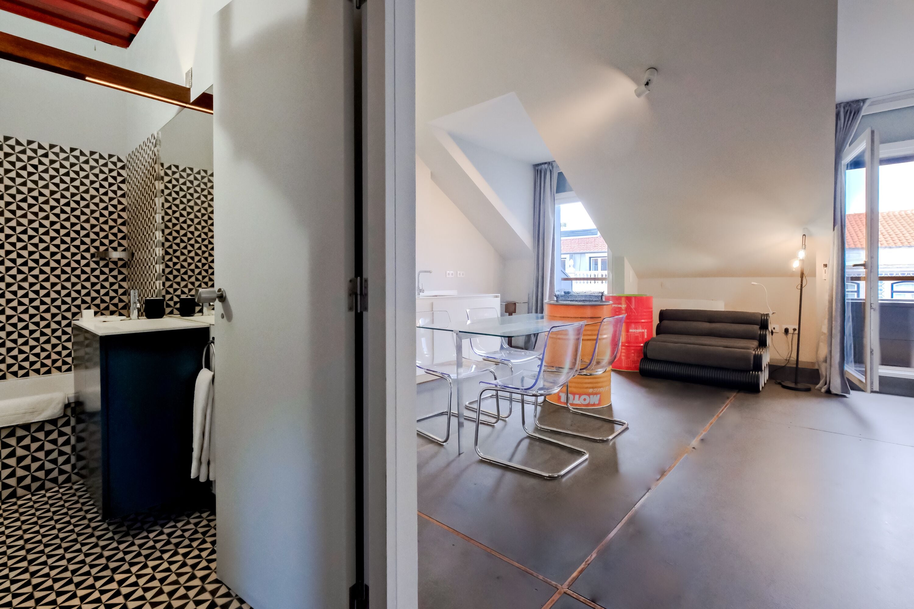 Um apartamento moderno com cozinha, área de refeições e banheiro com ladrilhos estampados geométricos.