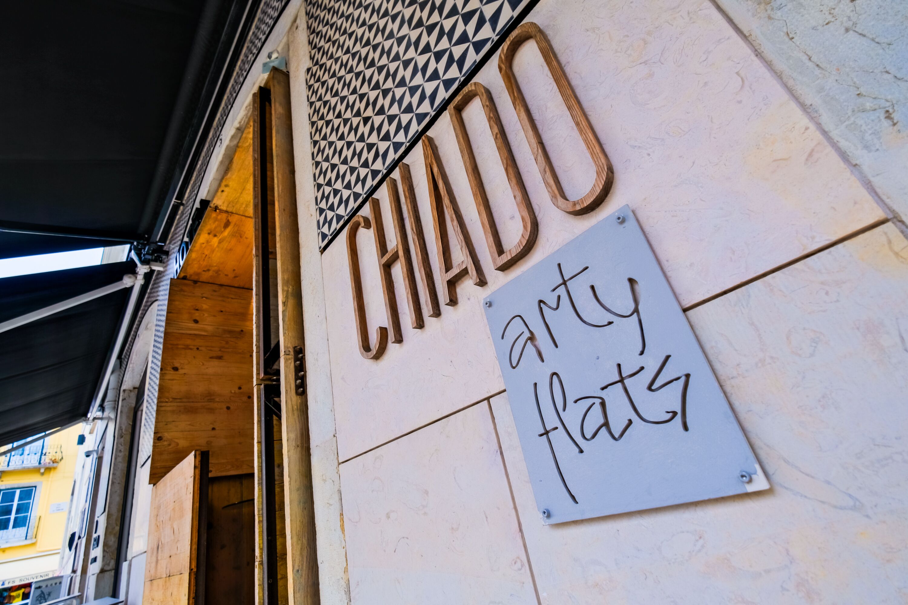 Un cartel que dice 'CHADO arty flats' con un techo decorado con un diseño geométrico.