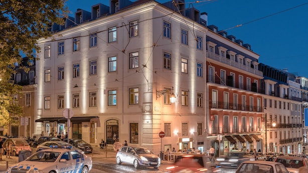A multi-story hotel with a classic facade, large windows, and a ground-level restaurant. - Chiado Arty flats (Lisbon)