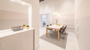 Eine moderne Küche mit weißer Arbeitsplatte, einem großen Spiegel und einer hängenden Pendelleuchte.