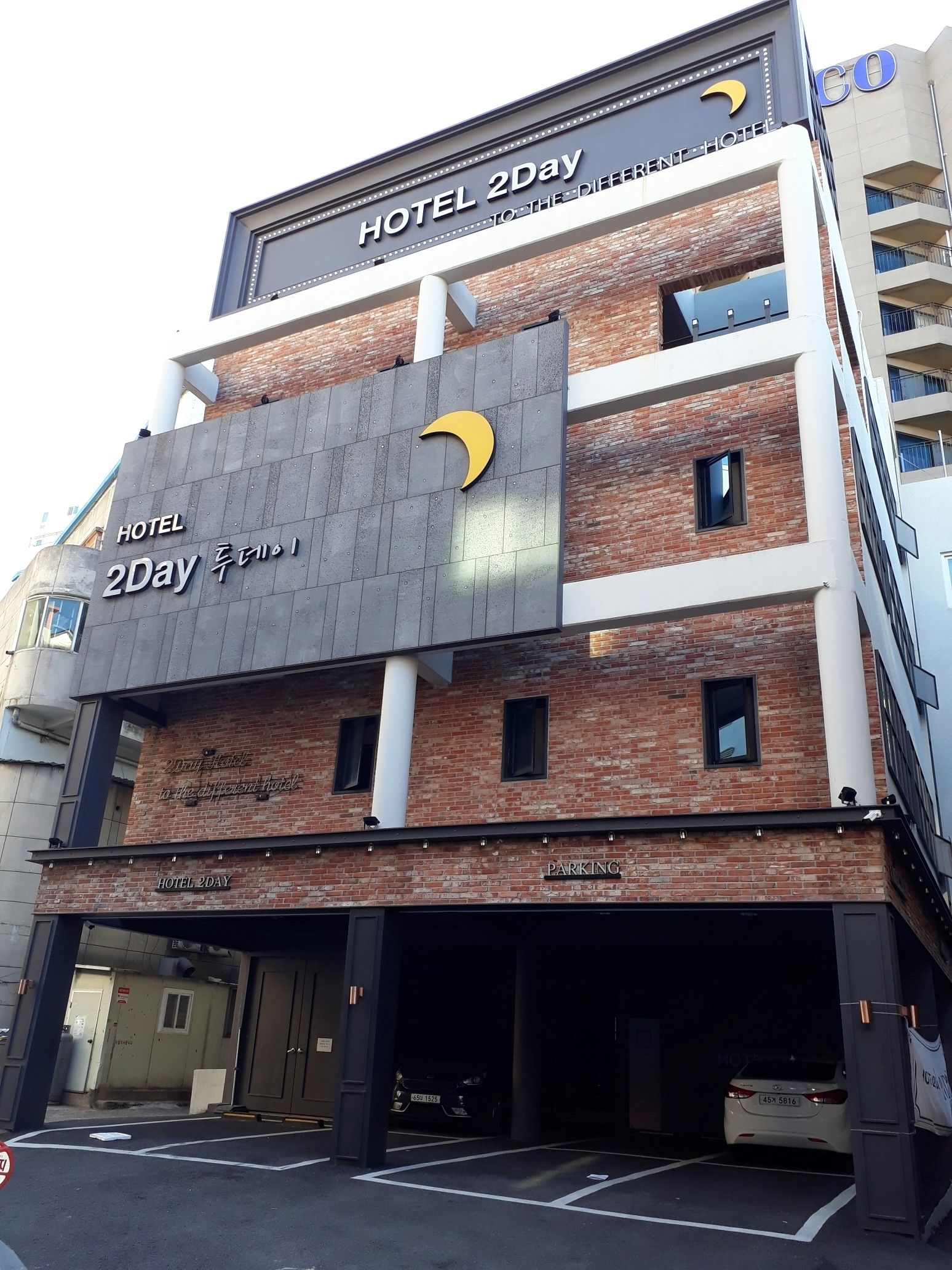 A multi-story building with a sign reading "HOTEL 2Day" and a crescent moon logo.