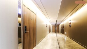 A hotel corridor with wooden doors, a digital keypad, and a marble floor. - 2day Hotel (Geoje)
