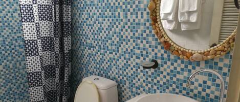 A bathroom with a toilet, sink, and shower curtain.