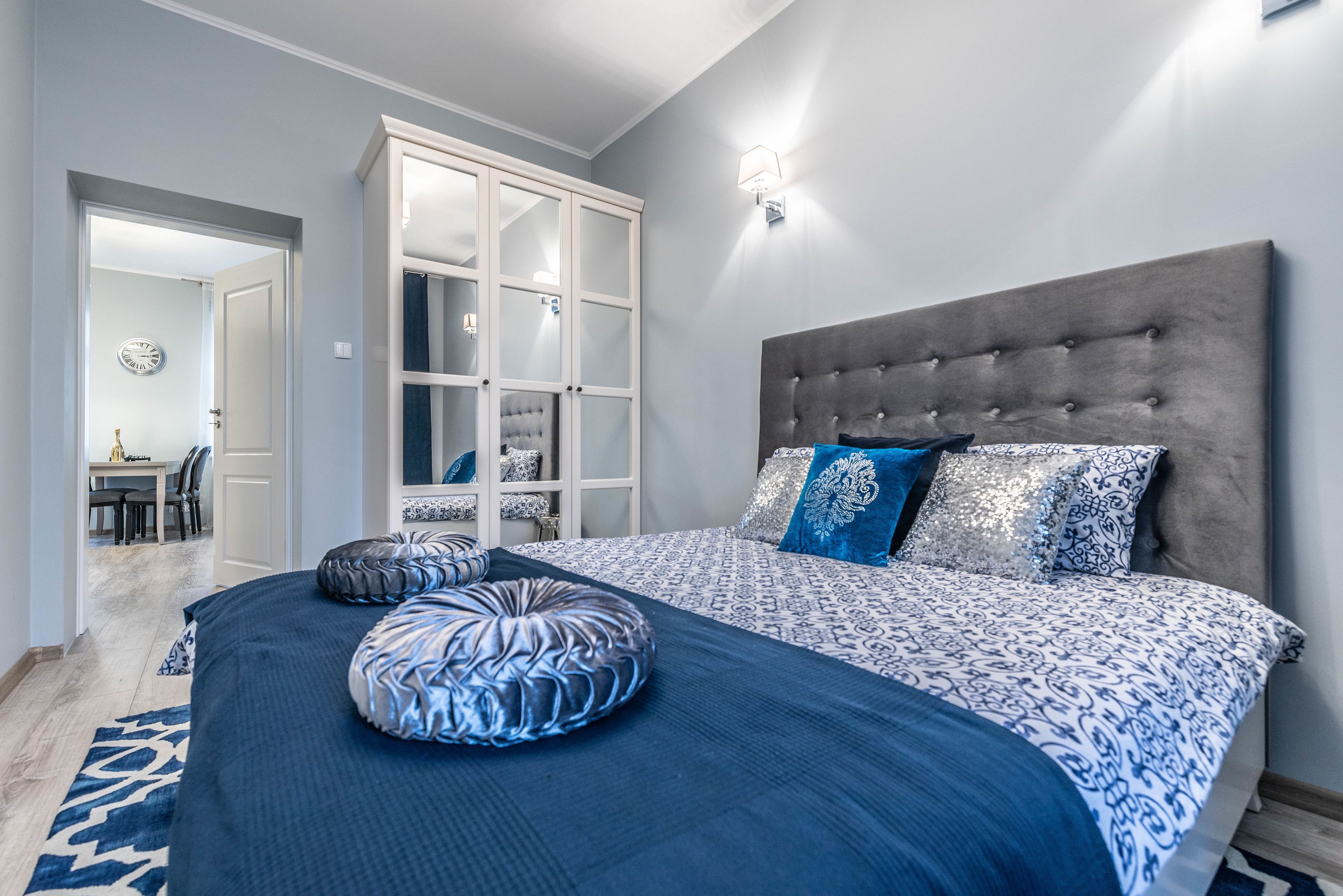 A bedroom with a large bed, a wardrobe, and a nightstand.