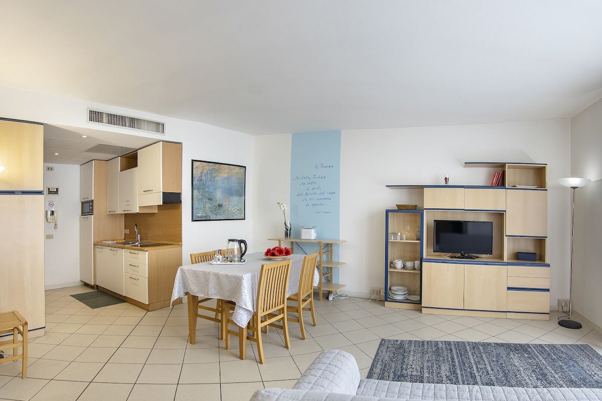 A compact living space with a kitchenette, dining area, and a TV area.