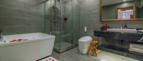 Ein modernes Badezimmer mit einer gläsernen Duschkabine, einer weißen Badewanne und einem Waschtisch mit Spiegel.