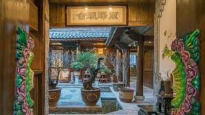 A traditional Japanese-style interior with wooden beams, a koi pond, and potted plants. - Lize Graceland Artistic Suite Inn (Lijiang)