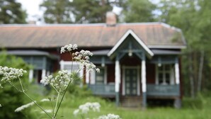 A rustic house with a gabled roof and a front door. - Sätra Brunn Hälsobrunn (Sala)