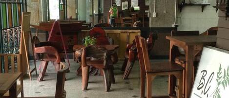 Interno di un ristorante con mobili in legno, una insegna e un orologio appeso al muro.