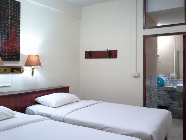 A hotel room with two beds, a wooden headboard, a wall-mounted lamp, and a mirror. - BC guesthouse Banglamphu (Bangkok)