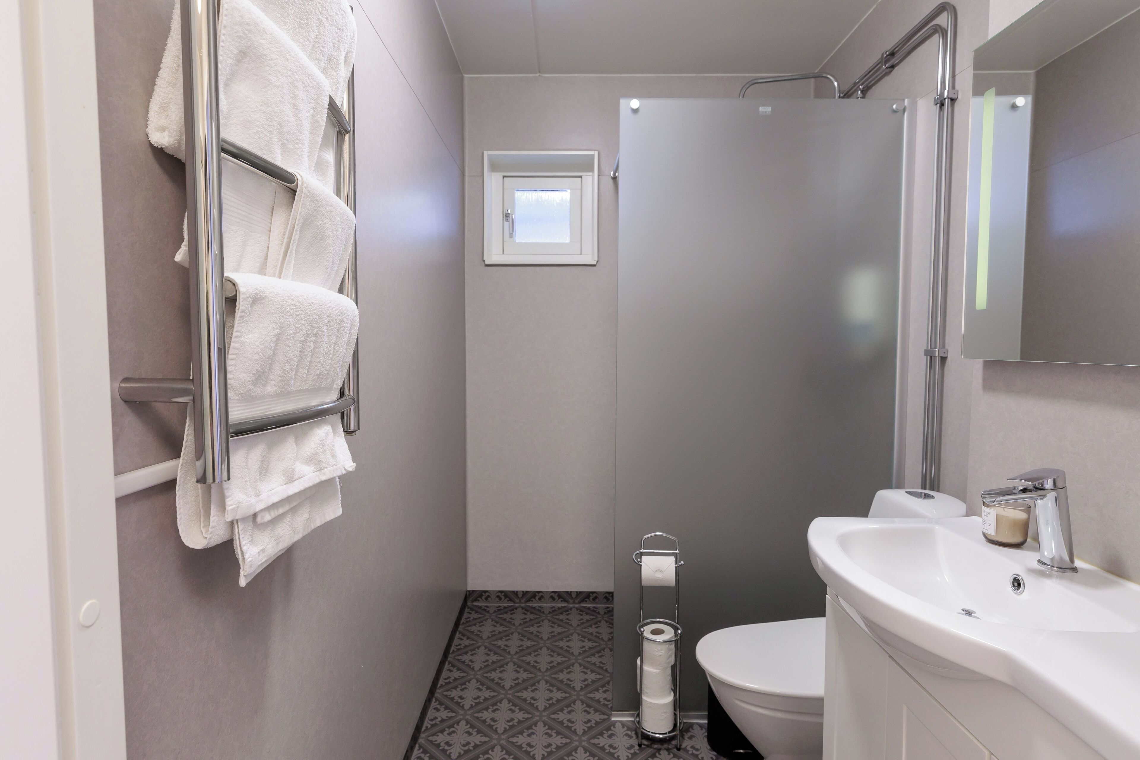 A bathroom with a toilet, sink, and towel rack.