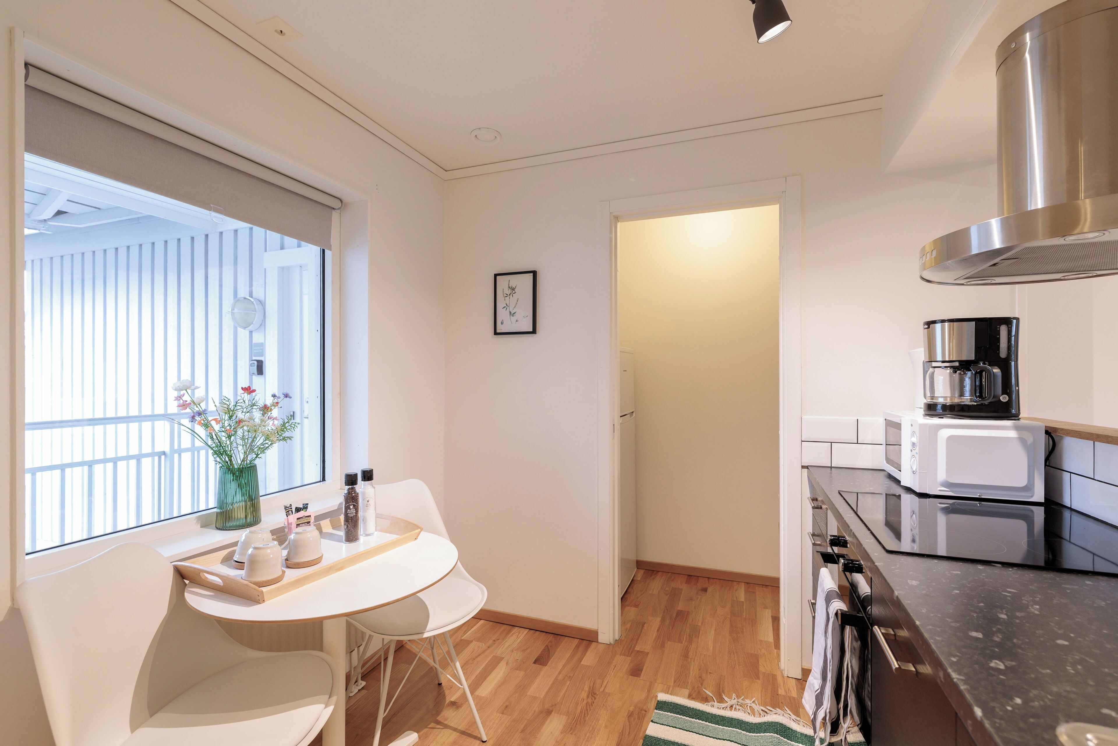 Cocina compacta con comedor, cafetera y microondas.