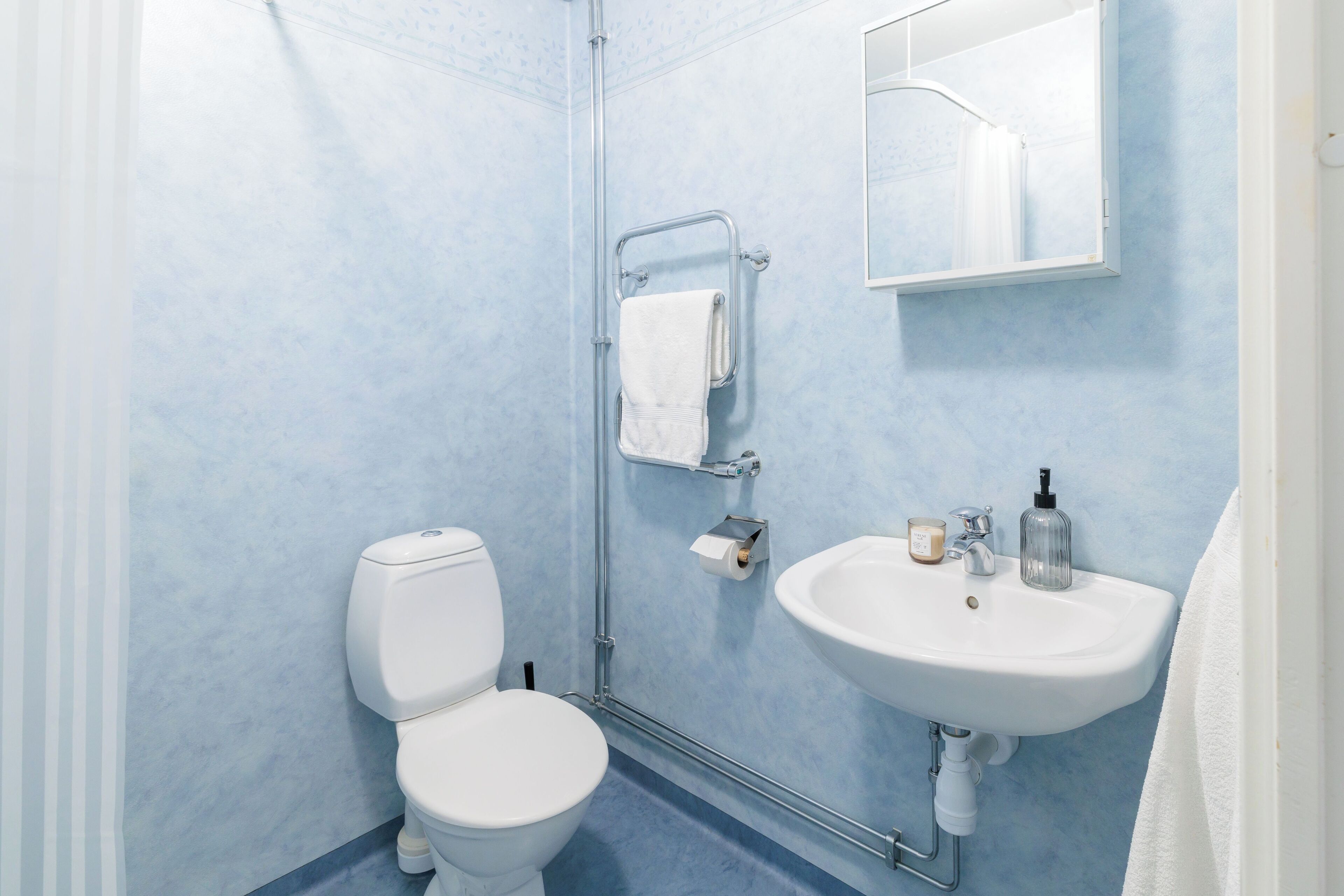 A bathroom with a white toilet, a sink, and a shower area.