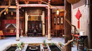 A traditional wooden interior with a central seating area, a small water feature, and decorative elements. - Huangshan Huizhou Creek Villa (Huangshan)