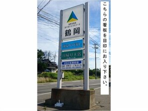 A signboard with multiple sections, including a logo at the top, and text in Japanese.