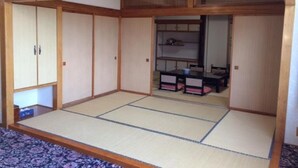 A traditional Japanese room with tatami flooring, sliding doors, and a small table with chairs. - Hotel Tetora Resort Tsuruoka (Tsuruoka)