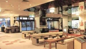 A spacious lobby with a seating area, a reception desk, and a large window offering a view. - Hotel Tetora Resort Tsuruoka (Tsuruoka)