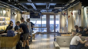 Un café avec un comptoir en bois, des tables et une grande fenêtre.