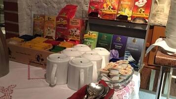 A buffet setup with various tea and coffee products, including branded boxes and mugs.