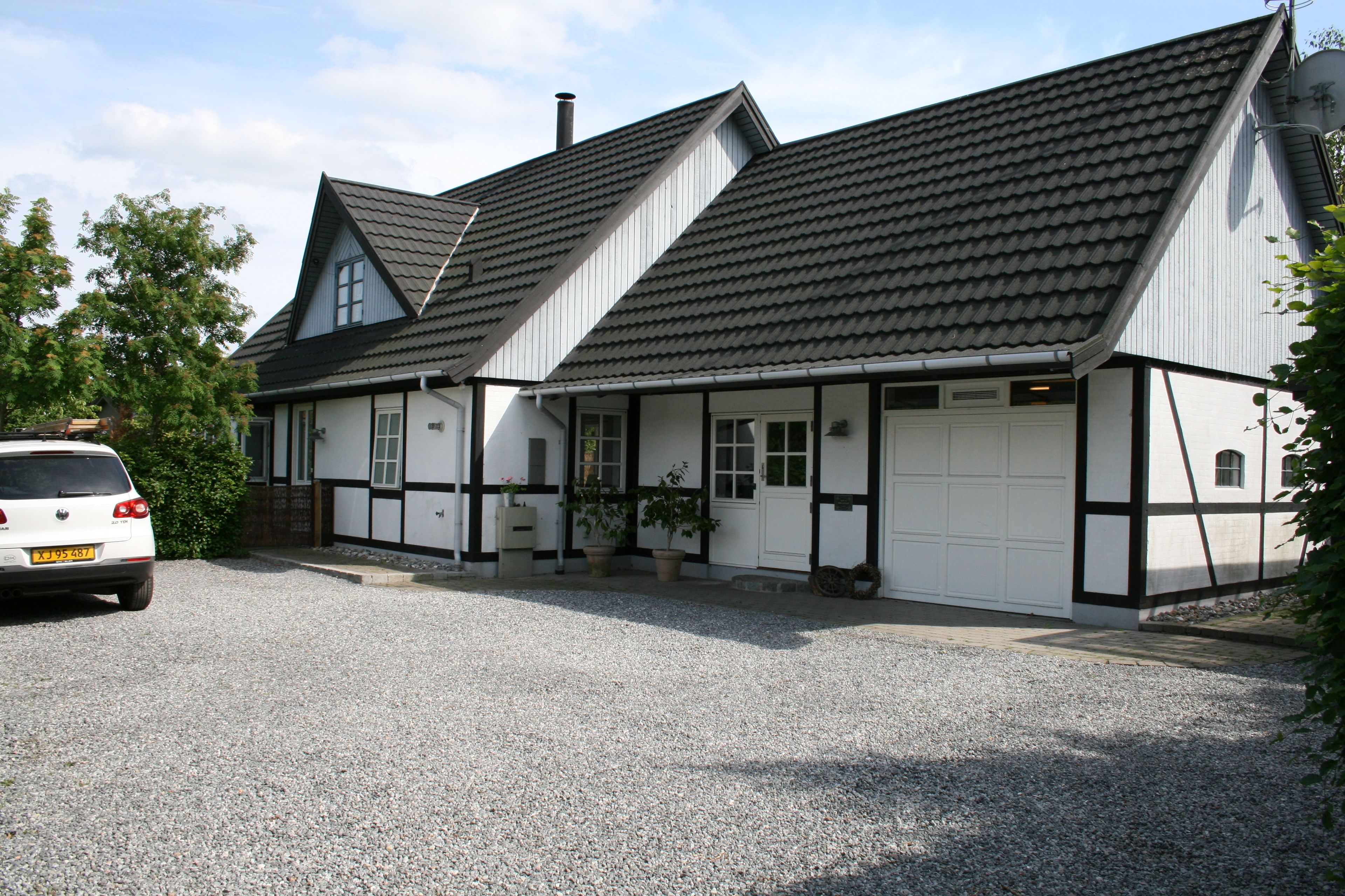 A two-story building with a gabled roof and a garage.