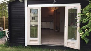 A compact, single-story cabin with a kitchen area visible through an open door. - Piccobello Bed & Breakfast (Koge)