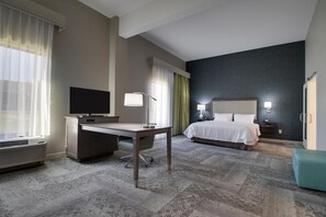 A hotel room with a bed, desk, television, and a patterned wall. - Hampton Inn & Suites Knightdale Raleigh (Raleigh)