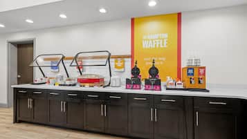 Una barra de desayuno con máquinas para hacer gofres y un letrero que dice The Hampton Waffle.