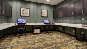 Una sala de conferencias con dos escritorios, sillas y dos monitores.