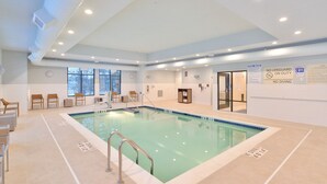An indoor swimming pool with clear lane markings, a lifeguard station, and a sign indicating no diving.