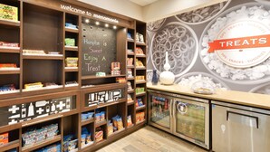 A snack display area with various packaged snacks and a chalkboard with a welcome message.