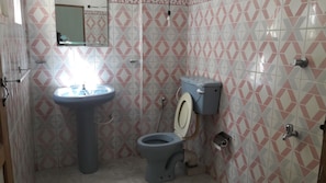 A bathroom with a pedestal sink, toilet, and a mirror above the sink. - Rooms One Five Four (Seeduwa - Katunayake)