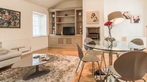 Una sala de estar moderna con sofá, mesa de centro y comedor con sillas y una mesa de vidrio.