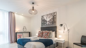 A modern hotel room with a large bed, bedside tables, a desk, and a chair. - The Michael Collins Suite - hiphipstay (Dublin)