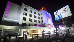 Un hotel con un letrero llamativo de GRT Hotels y un cartel grande que anuncia a GRT Jewelers.