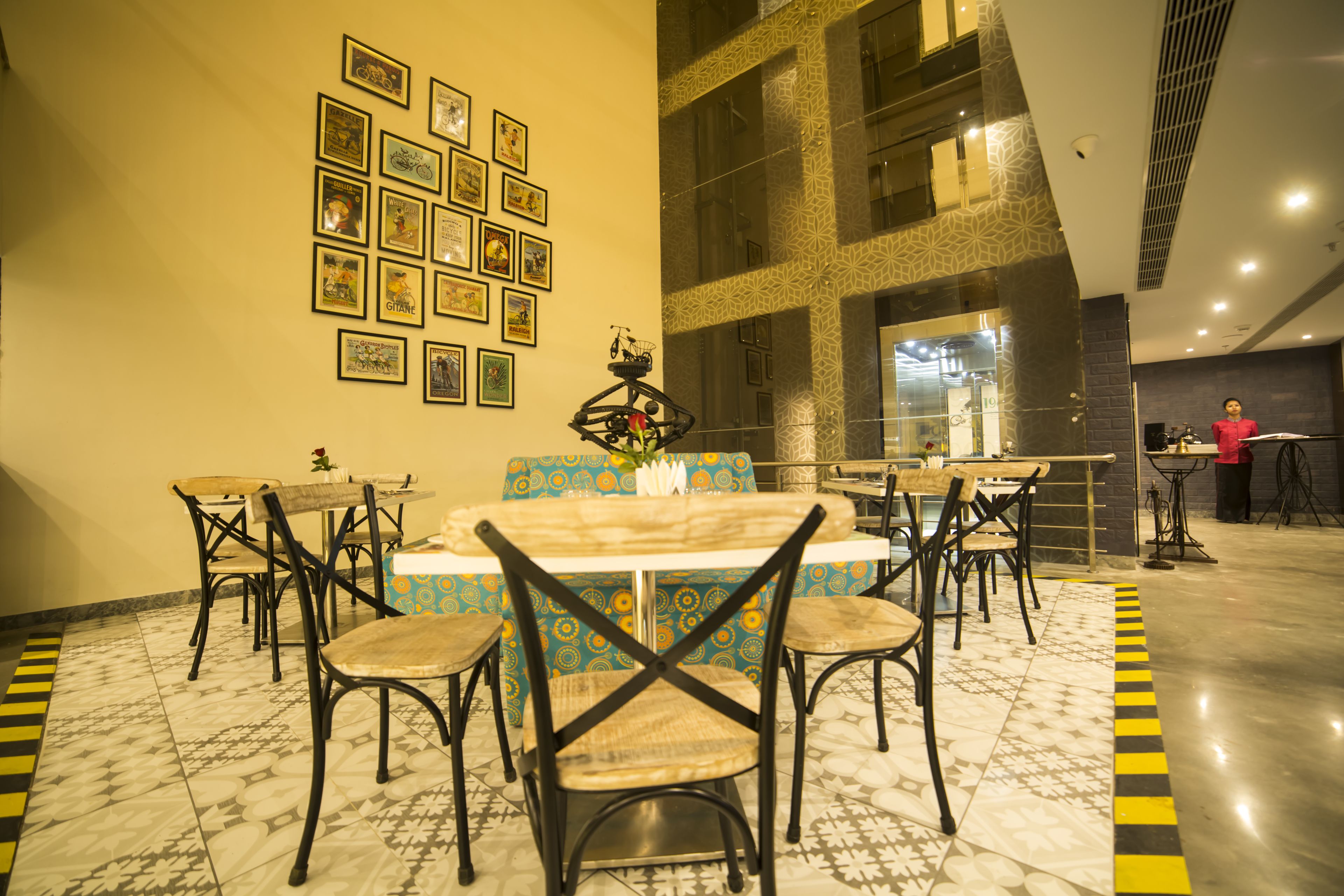 Un espace repas avec une table centrale, entourée de chaises, et un mur décoré de tableaux encadrés.