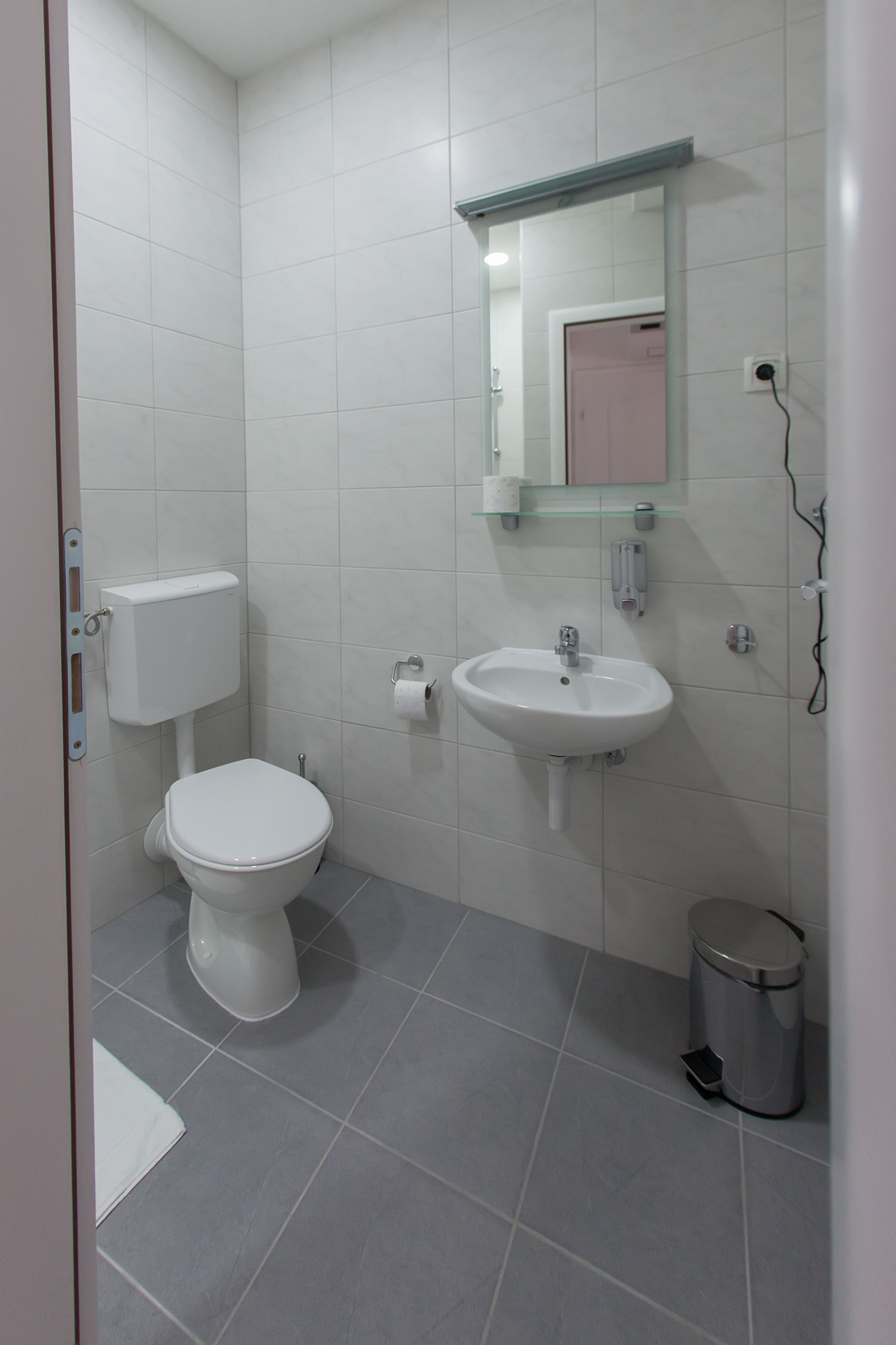 Une salle de bain avec des toilettes, un lavabo et un miroir.
