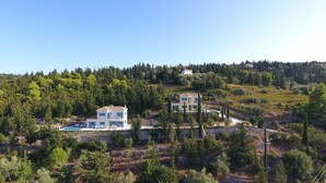 A two-story house with a swimming pool, surrounded by dense forest and hills. - Boo Premium Living Villas (Lefkada)