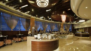 A modern hotel lobby with a central reception desk, seating area, and large windows with curtains. - Cenbest Jinling Grand Hotel (Wuhu)