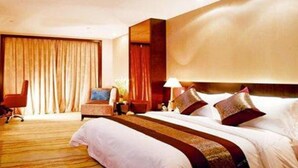 A hotel room with a large bed, a desk, a chair, and a large window with curtains. - Cenbest Jinling Grand Hotel (Wuhu)