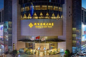 The exterior of the Jinling Grand Hotel with a prominent entrance, large glass windows, and a modern architectural design. - Cenbest Jinling Grand Hotel (Wuhu)