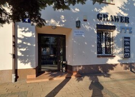 A building with a sign for 'GRAWER' and 'CRACOW CENTRAL APART HOTEL'.